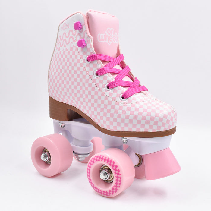 Patín quad OnWheels Soy Luna rosado con diseño de cuadros, vista de frente en ángulo