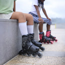 Niños sentados con los patines infantiles ajustables Globber con luces puestos