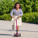 Niña andando en el scooter Globber ACE Lights Fucsia en un parque