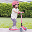 Niña con casco andando en el scooter de 3 ruedas Globber Junior Plegable Lights Fuchsia