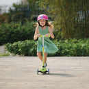 Niña andando en el scooter Globber Primo Lights Lime Green en un parque