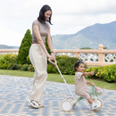 Mamá guiando a su hija en el triciclo evolutivo Globber 3 en 1 Plus Pistachio con la manilla para papás