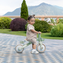 Niña sentada en el triciclo evolutivo Globber 3 en 1 Plus Pistachio al aire libre
