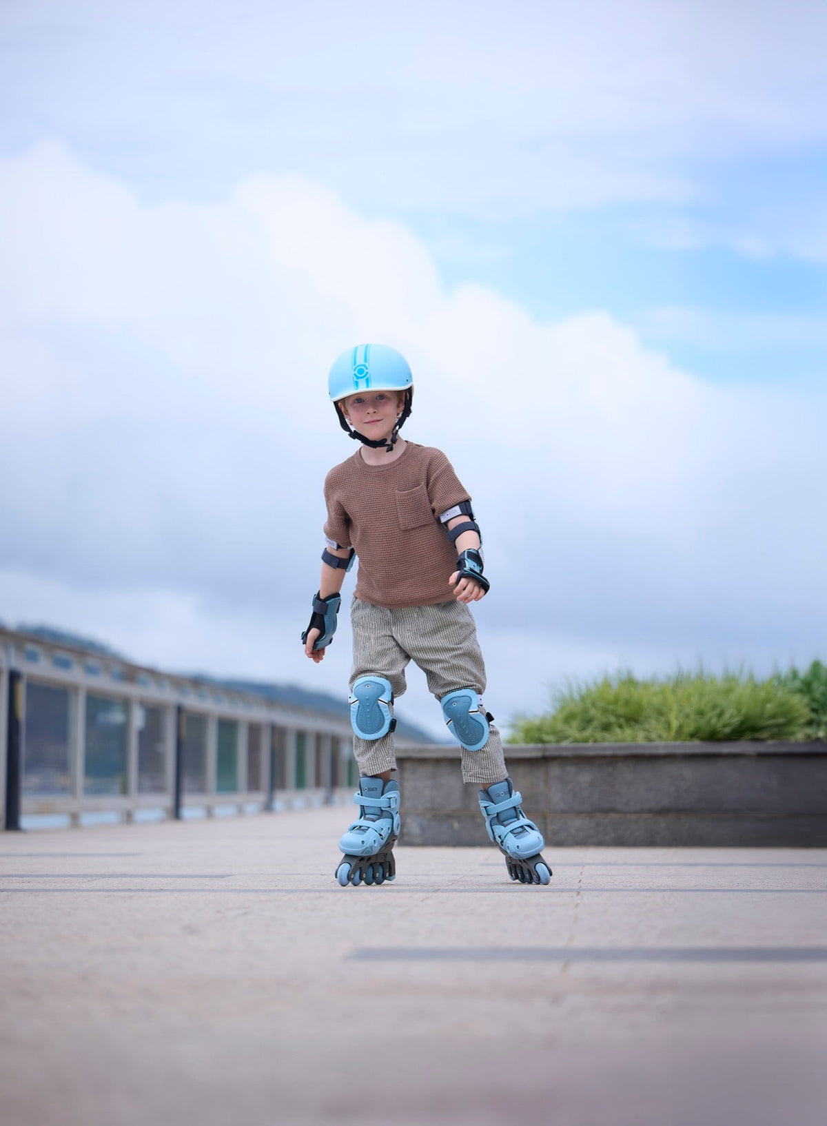 Niño con casco, rodilleras y patines Globber